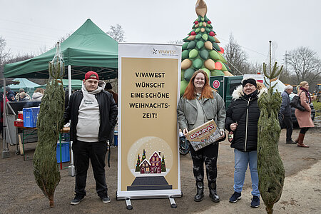 Mieter aus dem VIVAWEST-Quartier Bergmannsgrün posieren auf dem Mini-Weihnachtsmarkt im Quartier. 